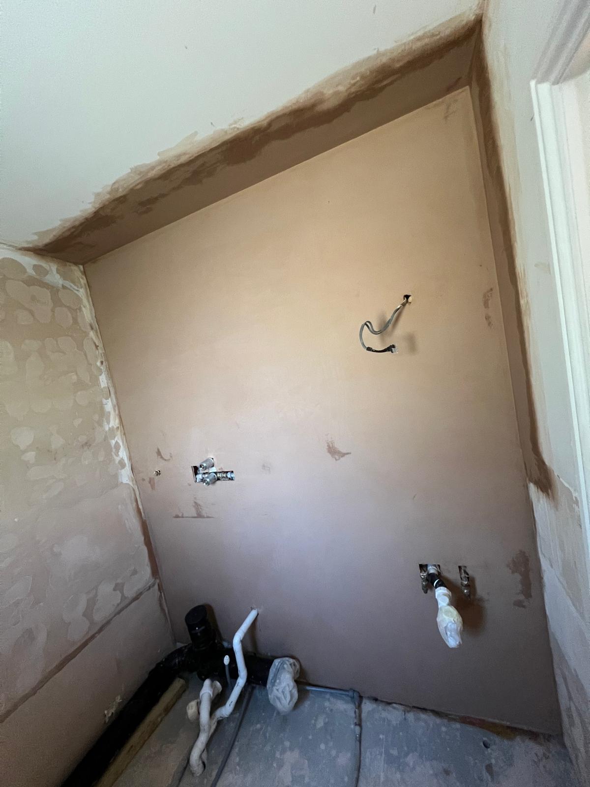 Plastered wall around plumbing